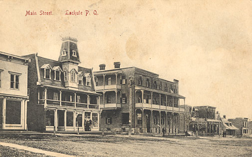 L'hôtel Rodrigue et le magasin Bauford situés sur la rue Principale qui est en terre battue avec des trottoirs en bois