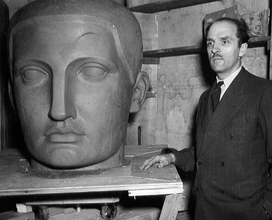Un homme posant devant une sculpture dans un atelier de sculpture lors d'un reportage photographique à Montréal, 1947
