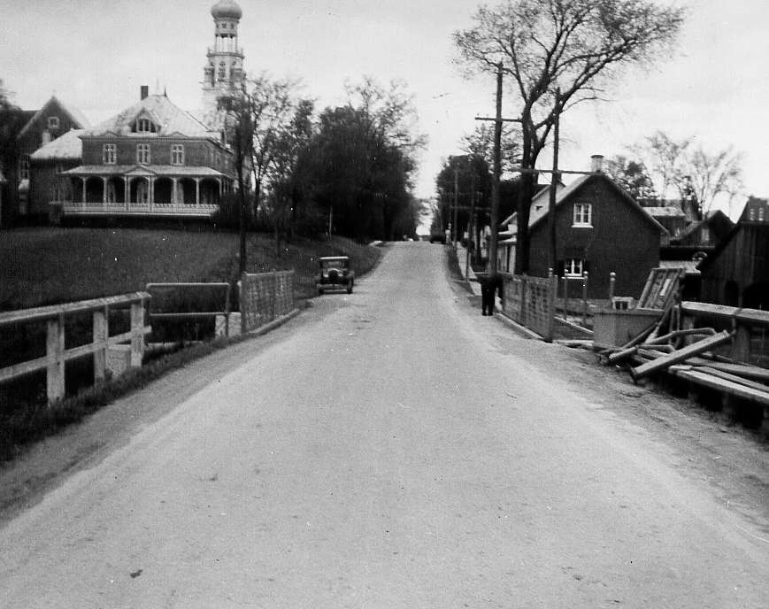 Pont Tour-du-Lac, l'église etquelques résidences, en arrière-plan, à St-Adolphe d'Howard dans le comté d'Argenteuil en 1947