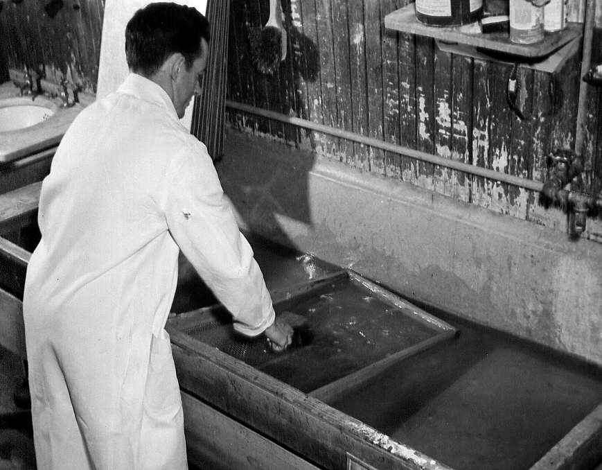 Un homme nettoyant des objets au couvoir de St-Hyacinthe en 1947
