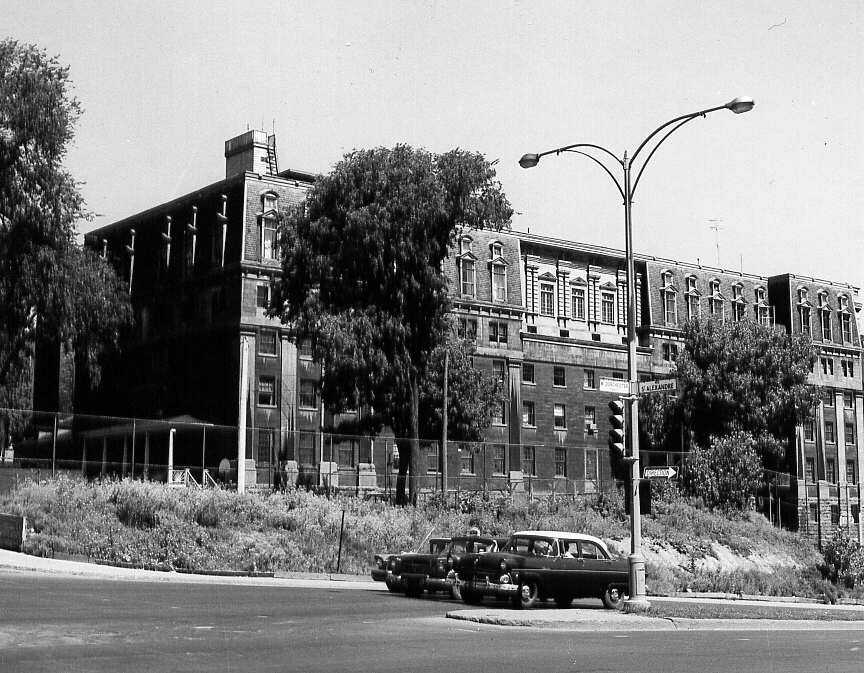À Montréal en 1961, rue Dorchester avec des automobiles et un immeuble en arrière-plan 