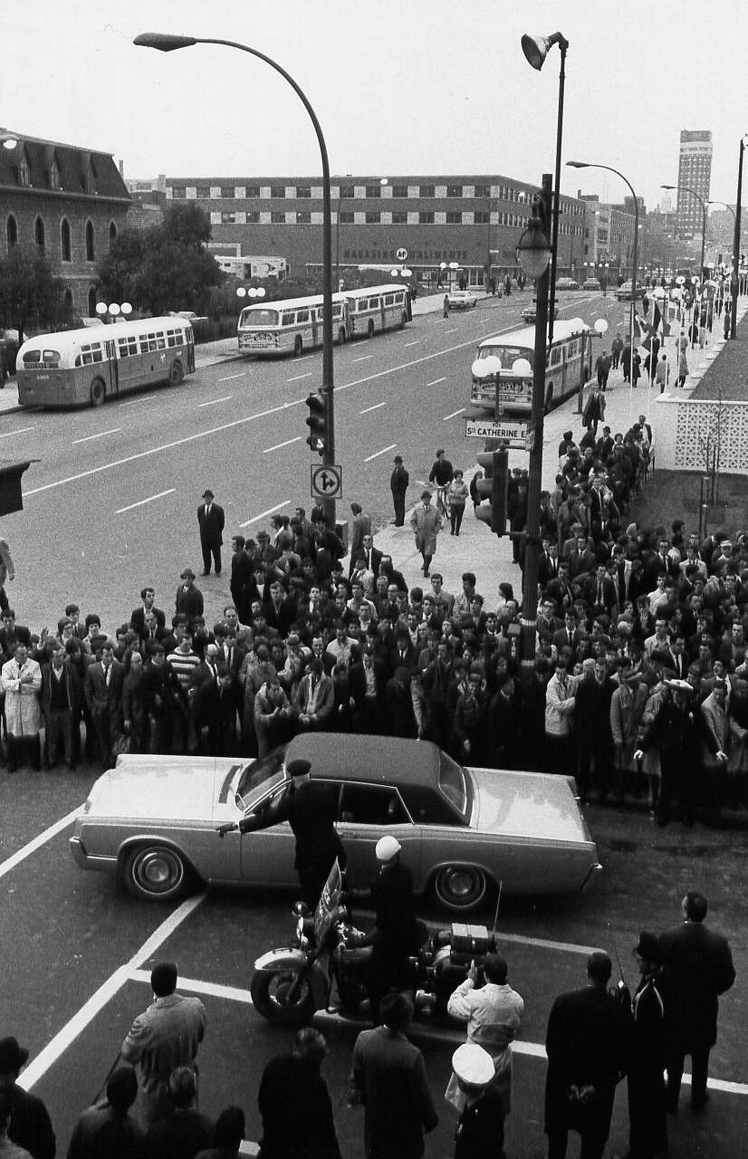 Voiture des dignitaires entourée d'une foule lors de l'inauguration du métro de Montréal en 1966