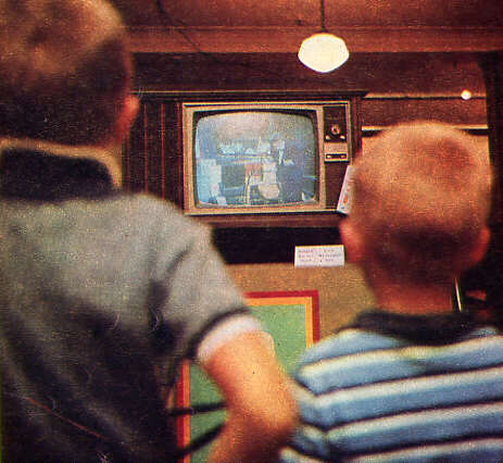 Deux garçons regardent une télévision en couleurs