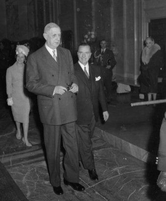 Le général Charles de Gaulle et le maire Sarto Fournier dans le hall d'honneur de l'hôtel de ville de Montréal, suivis de leur épouse