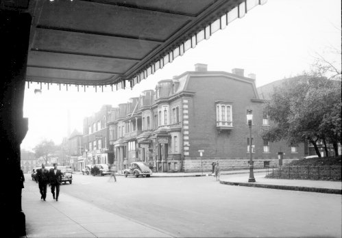 Photographie de propriétés et de commerces sur la rue Osborne (aujourd'hui rue de la Gauchetière) à l'angle de la rue Stanley, à partir de la gare Windsor