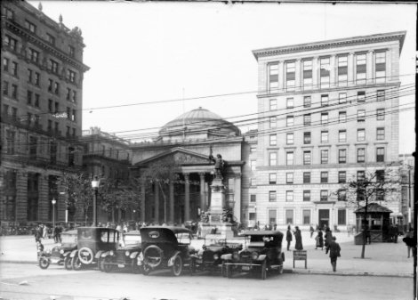 Photographie de la place d'Armes: on y voit le monument Maisonneuve de même que le siège social de la Banque de Montréal