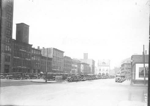 Le stationnement de la place d'Youville dans les années 1930: on y aperçoit la caserne centrale des pompiers (aujourd'hui le Centre d'histoire de Montréal), de même que les édifices des commerces Rose & Laflamme, Frank P. Lalonde et Mallinckrodt Chemical