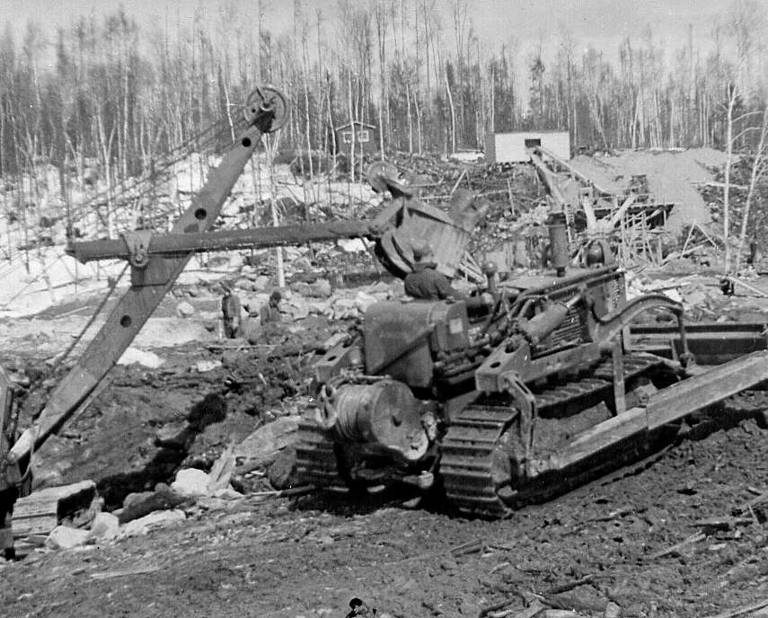 Travailleurs et machinerie lourde lors de la construction du pont de la rivière Camatose, dans le comté de Pontiac
