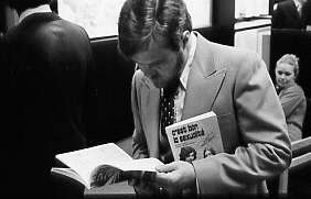 Homme consultant un livre lors du lancement du volume «Action, Décision, Information» à la librairie de l'Éditeur officiel au complexe Desjardins, Montréal, 1977