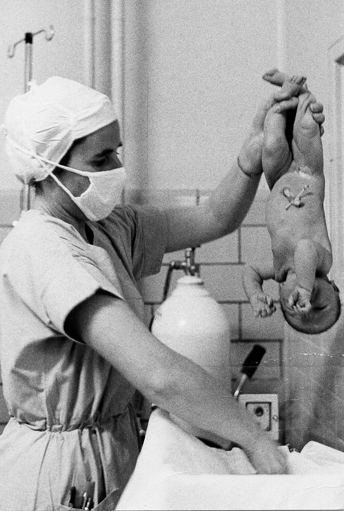Une infirmière tient le nouveau né après son premier bain