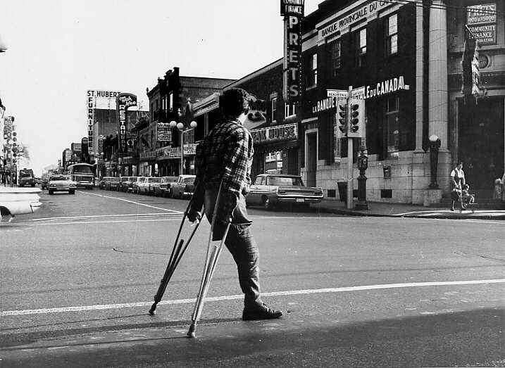 Un homme amputé d'une jambe traversant la rue au coin de Beaubien et St-Hubert à Montréal